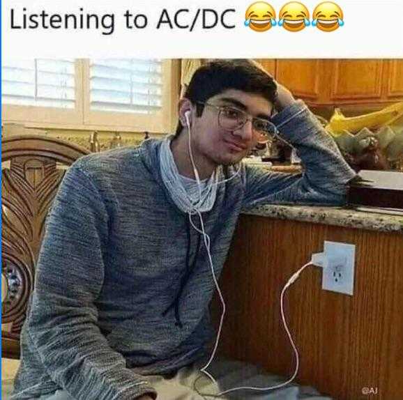 man sitting at a counter with headphones on listening to ac / dc