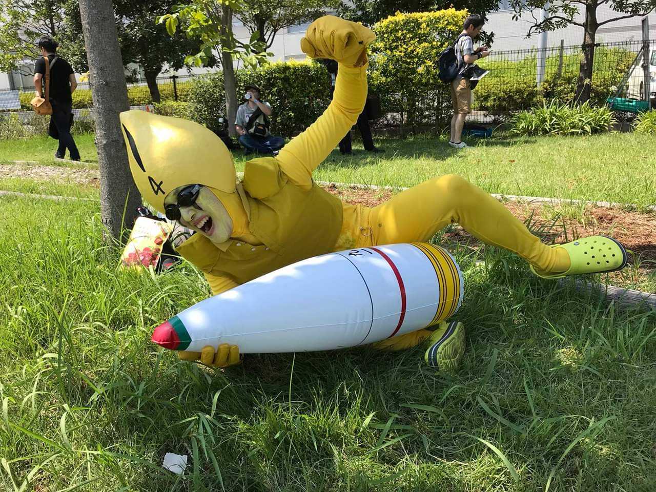 araffe in a yellow suit laying on the ground with a white rocket