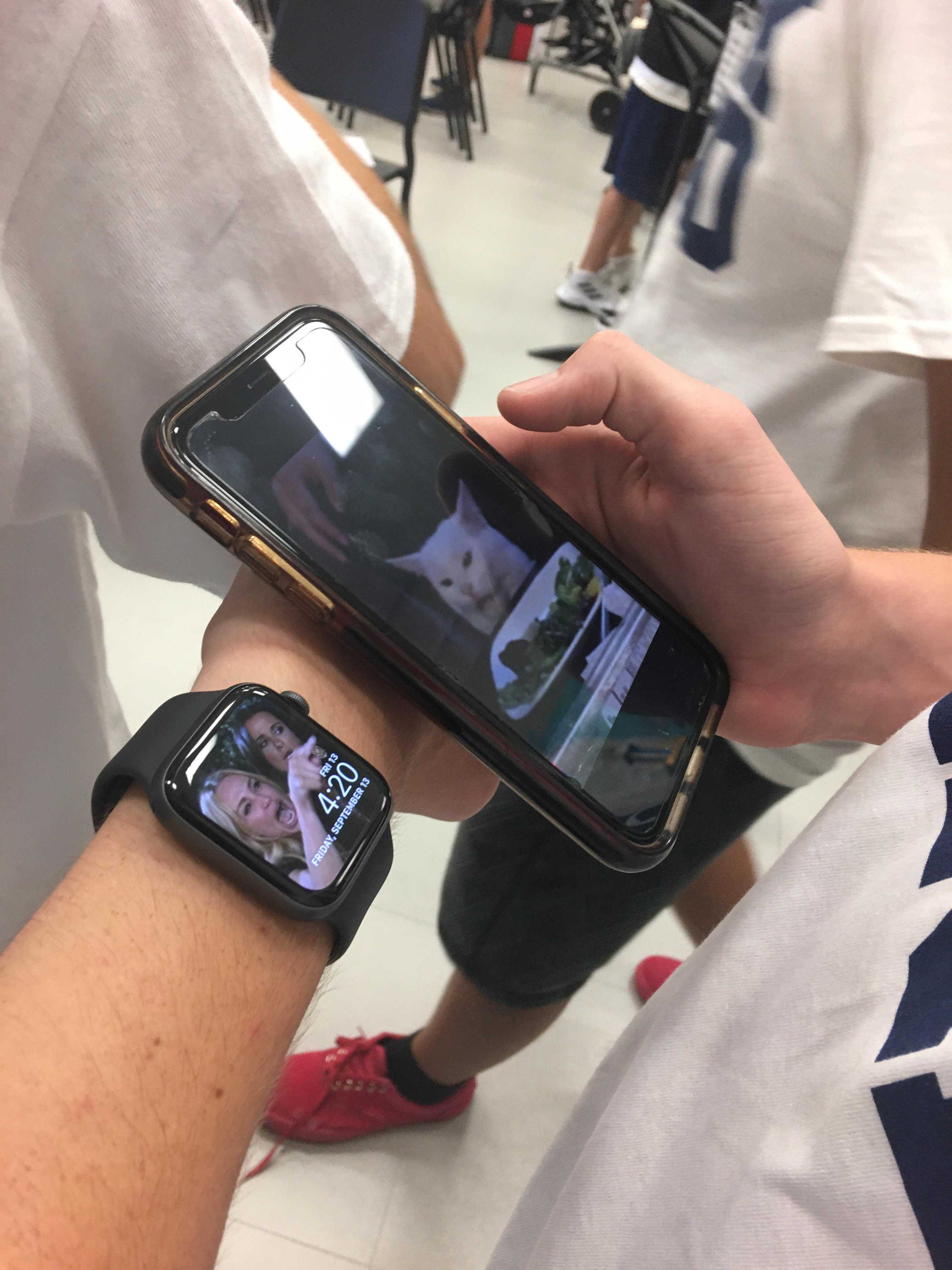 someone is holding a smart phone and a smart watch