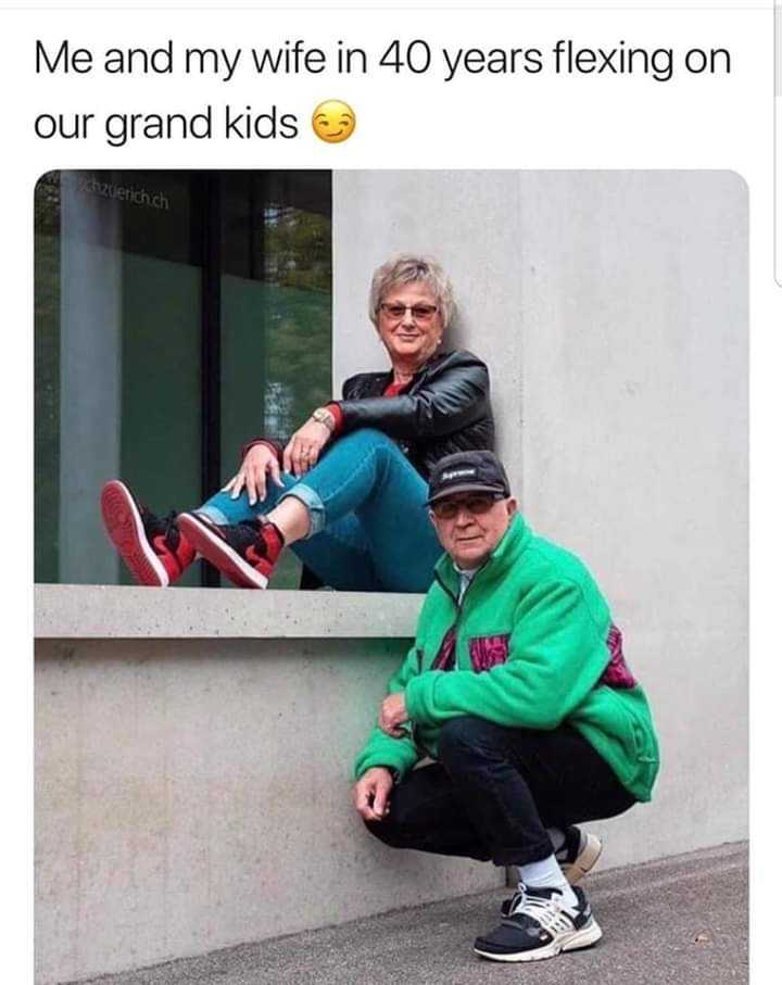 man and woman sitting on a ledge with a smile on their faces