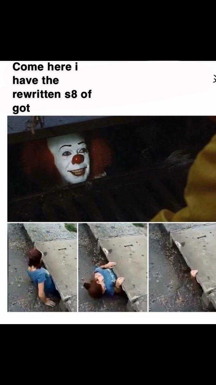 clown with a red nose and a white face is sitting on the ground