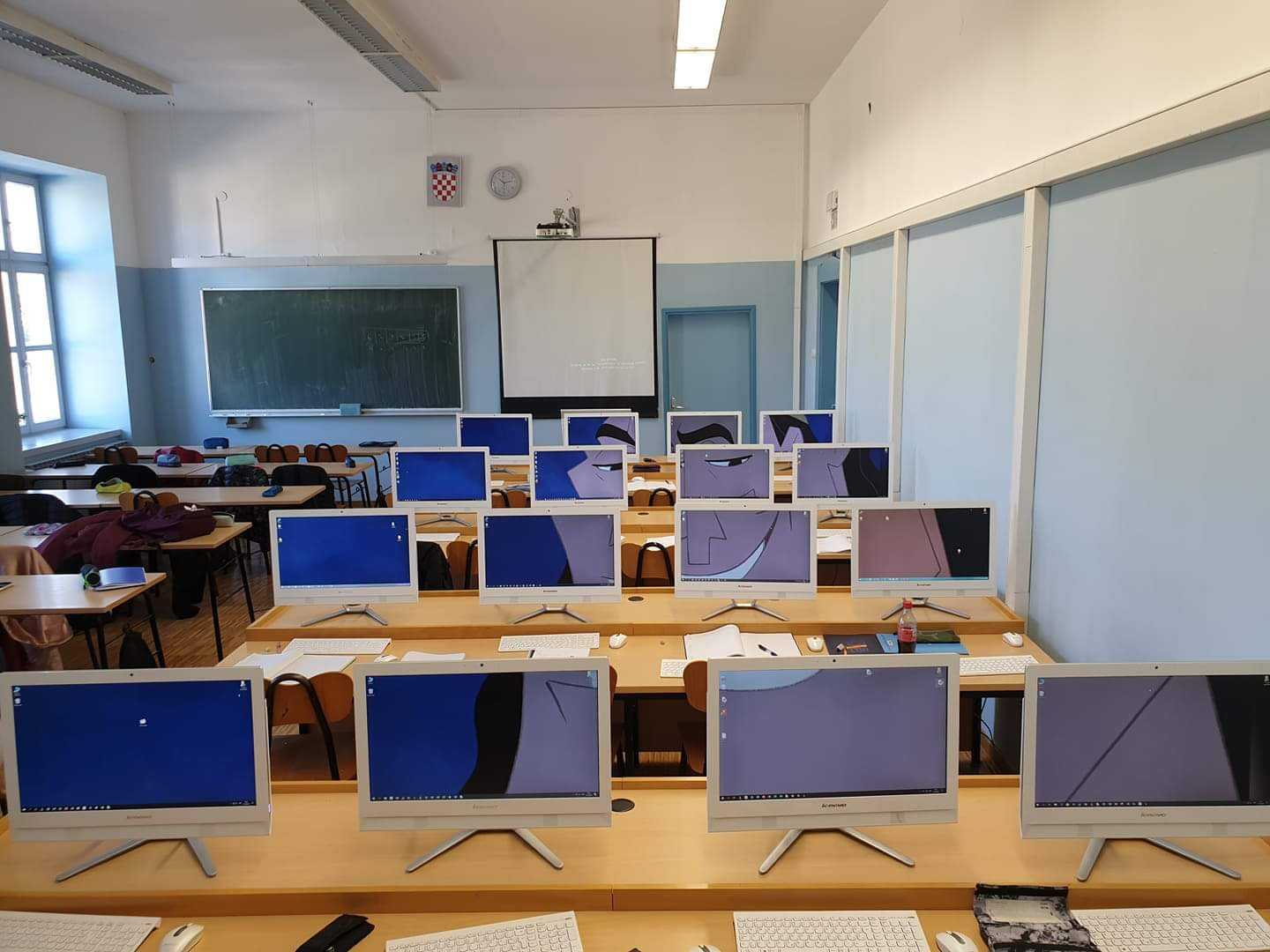 there are many computers on the desk in the classroom