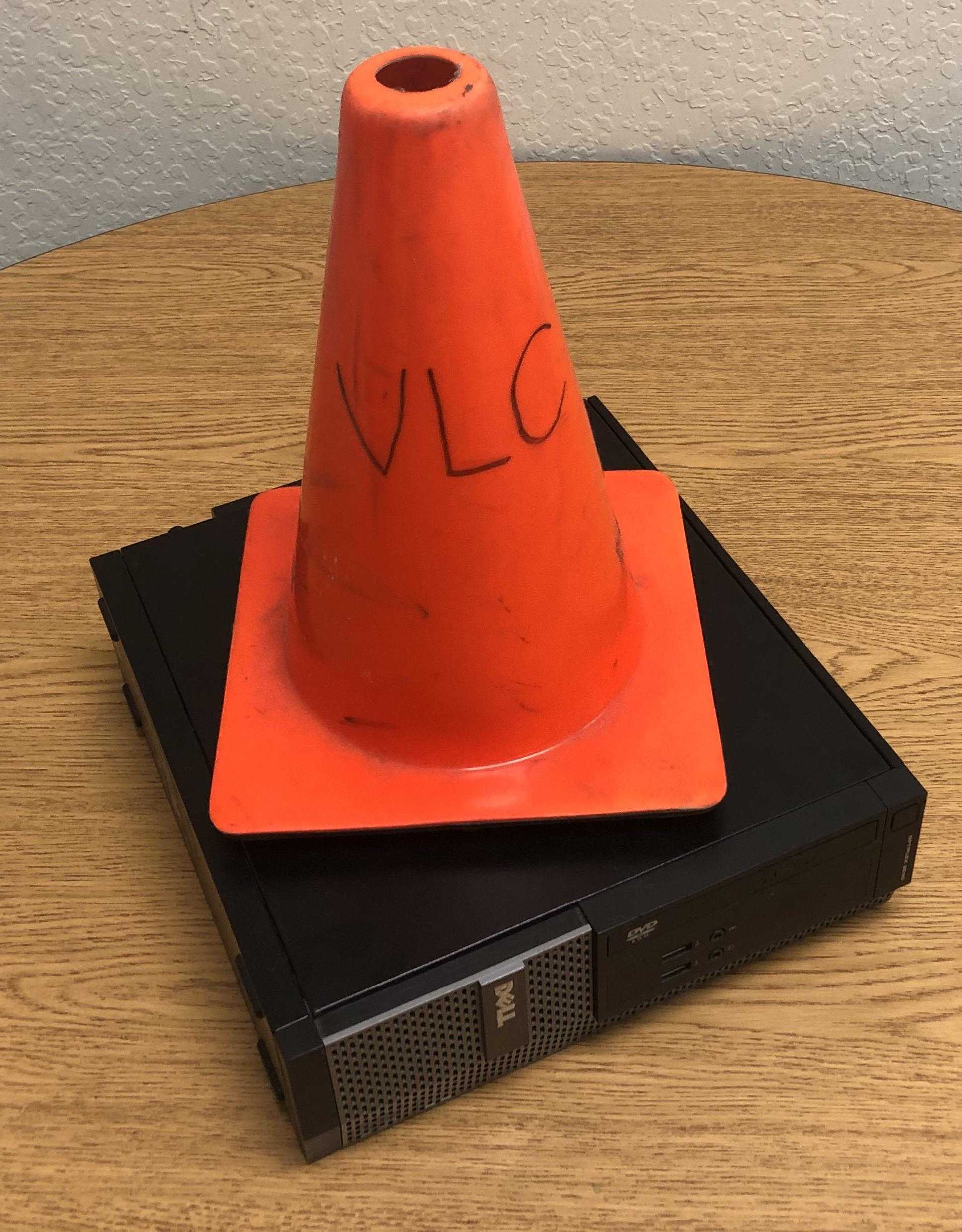 there is a orange cone sitting on top of a dvd player