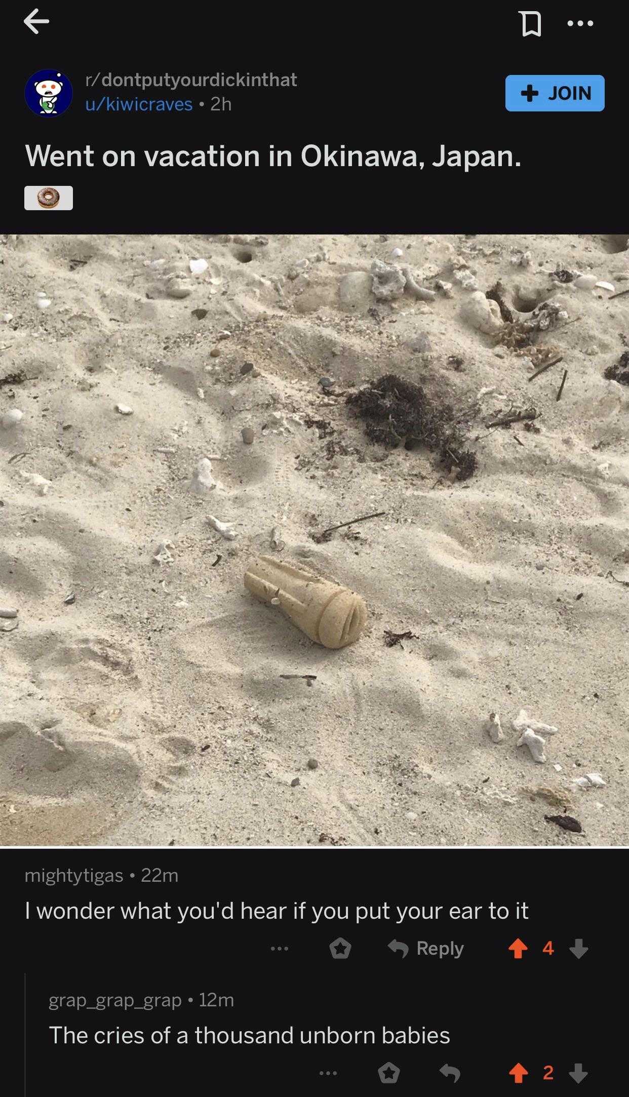 a close up of a bottle of water on a beach