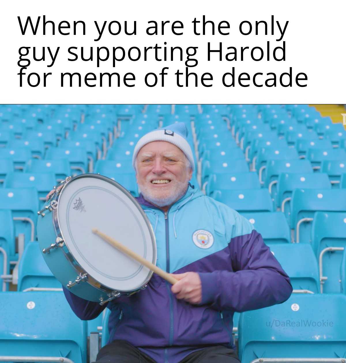 man sitting in a stadium holding a drum and a drum stick