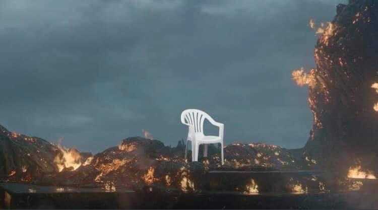 there is a white chair sitting on a fire covered hill