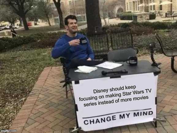 man sitting at a table with a sign that says change my mind