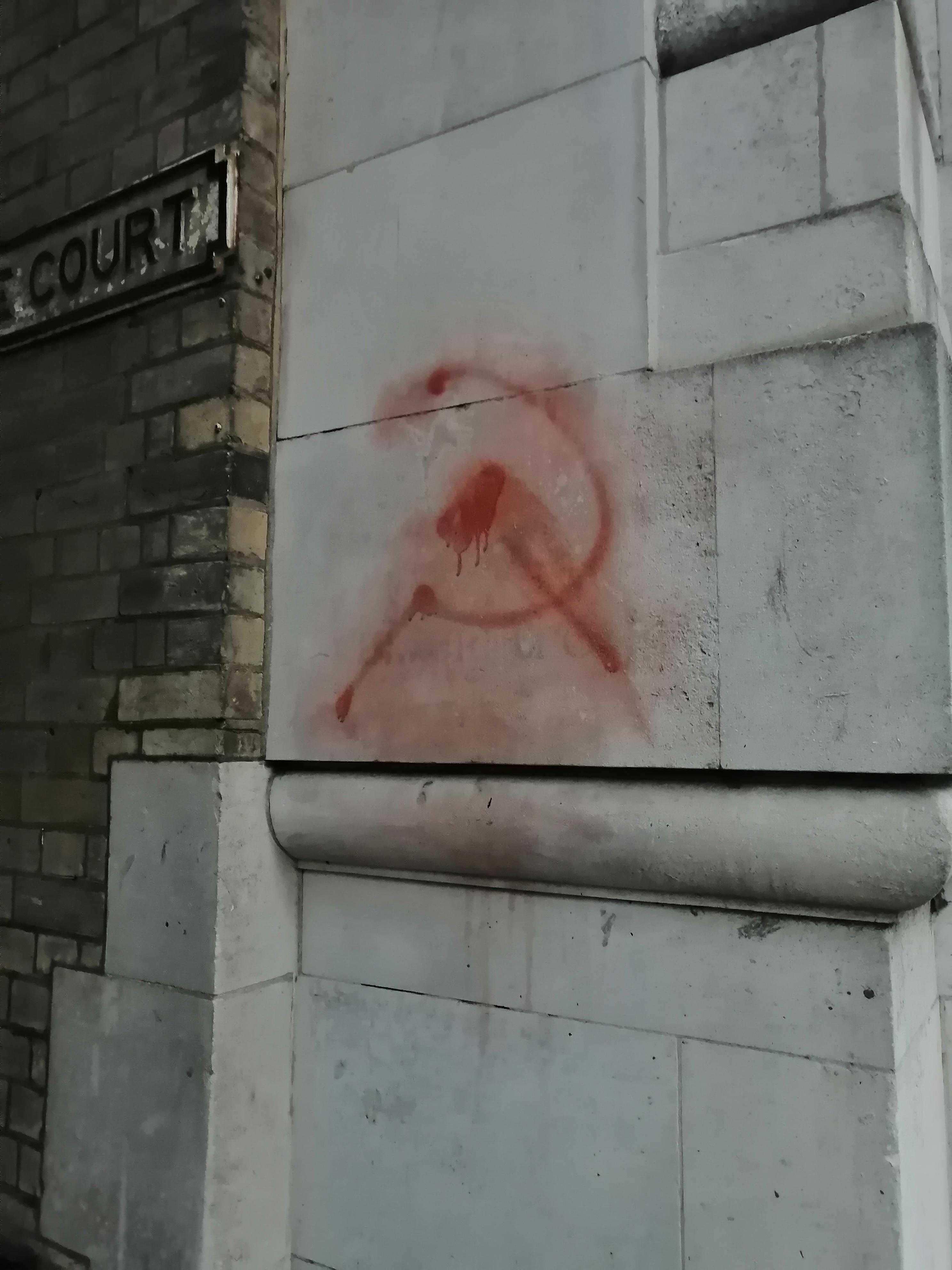 graffiti on a building with a hammer and sick hammer on it