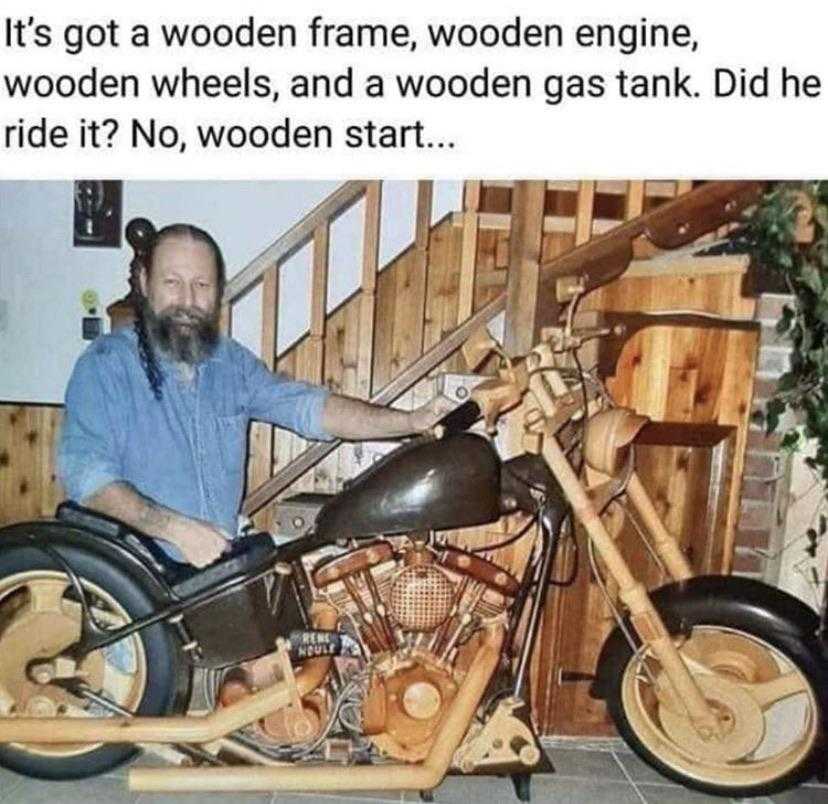 man sitting on a wooden motorcycle with a wooden frame