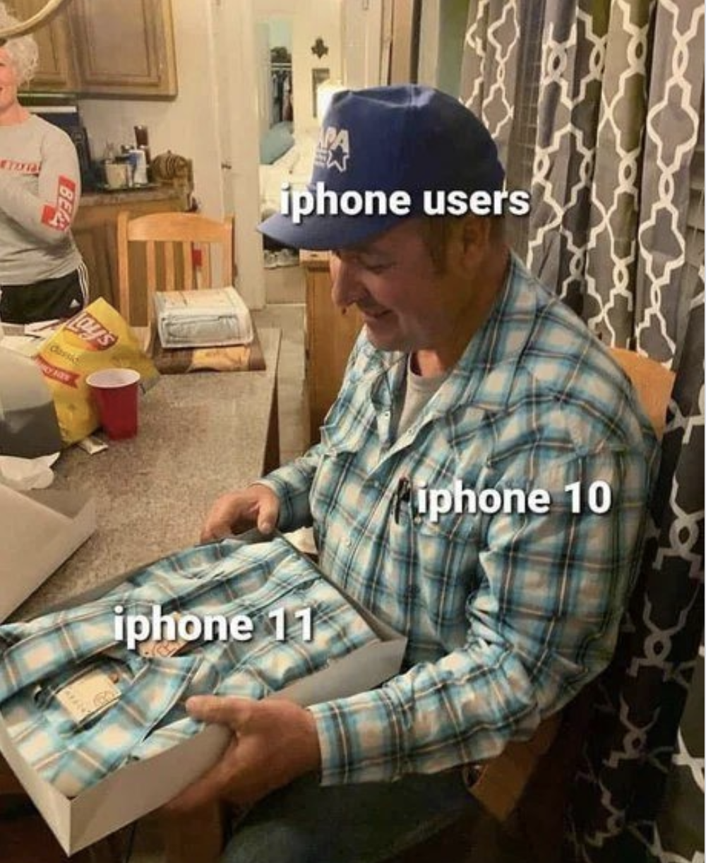 a man sitting in a chair holding a box of iphones