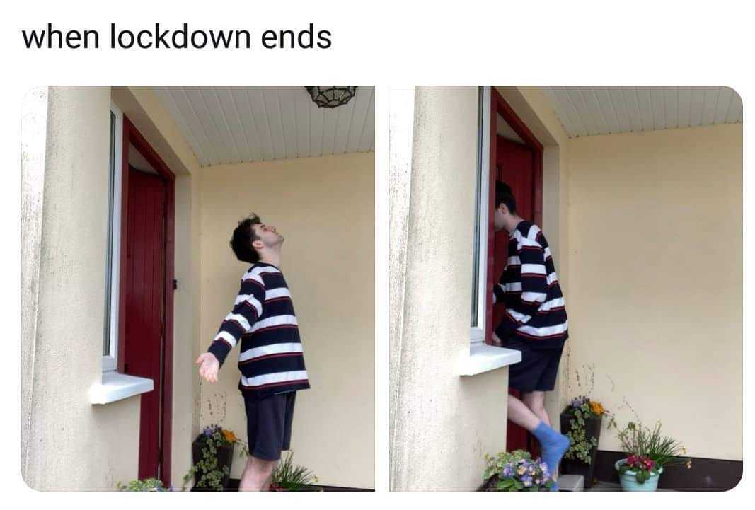 man standing on a ledge looking out a window