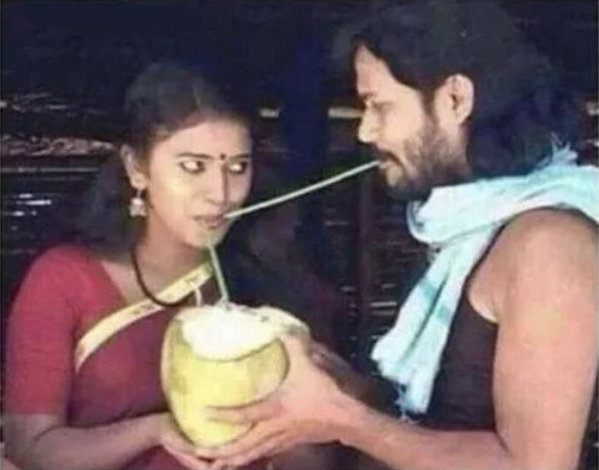 a man and woman holding a coconut drink in their hands