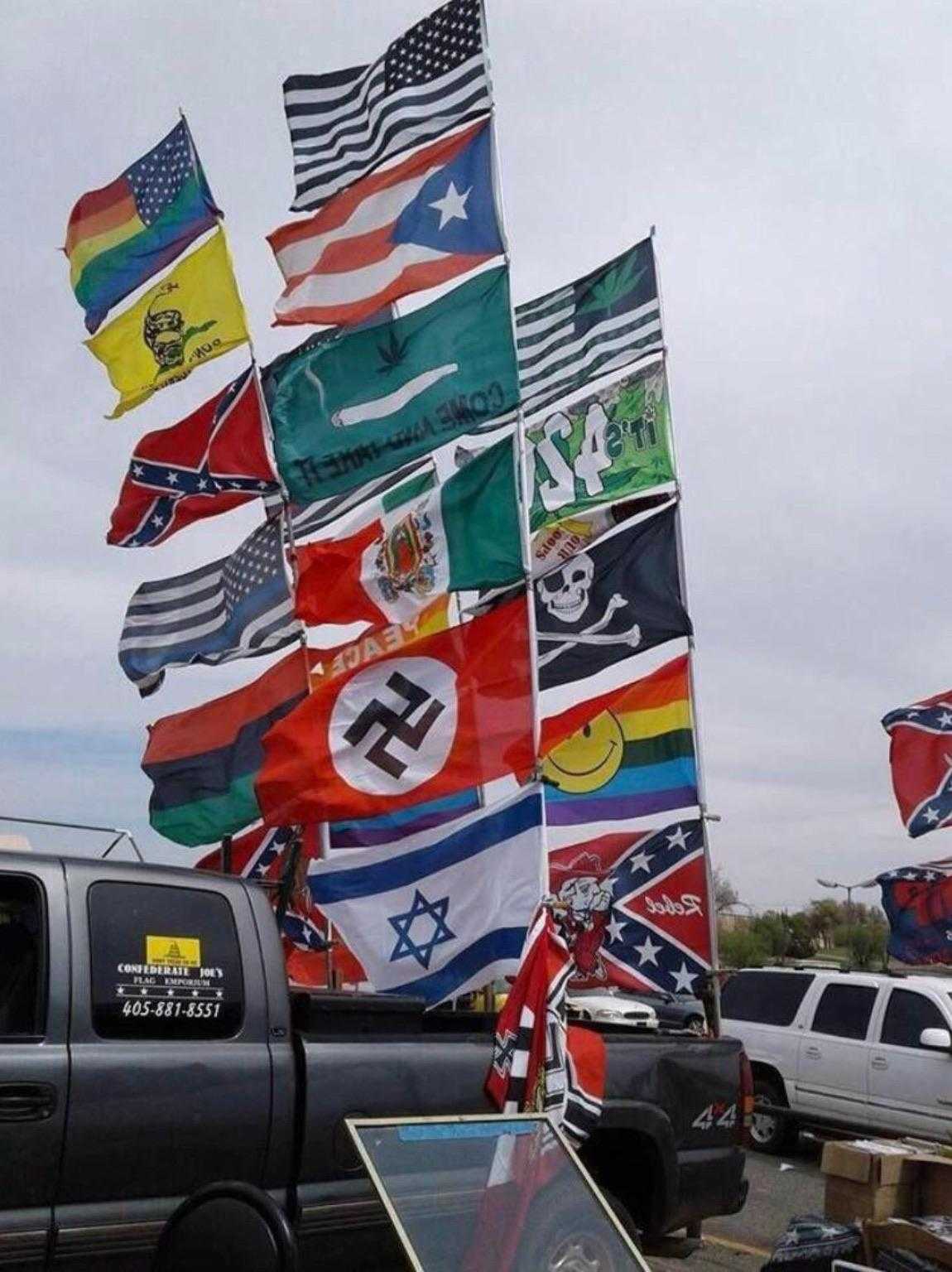 flags of different countries are flying in a parking lot