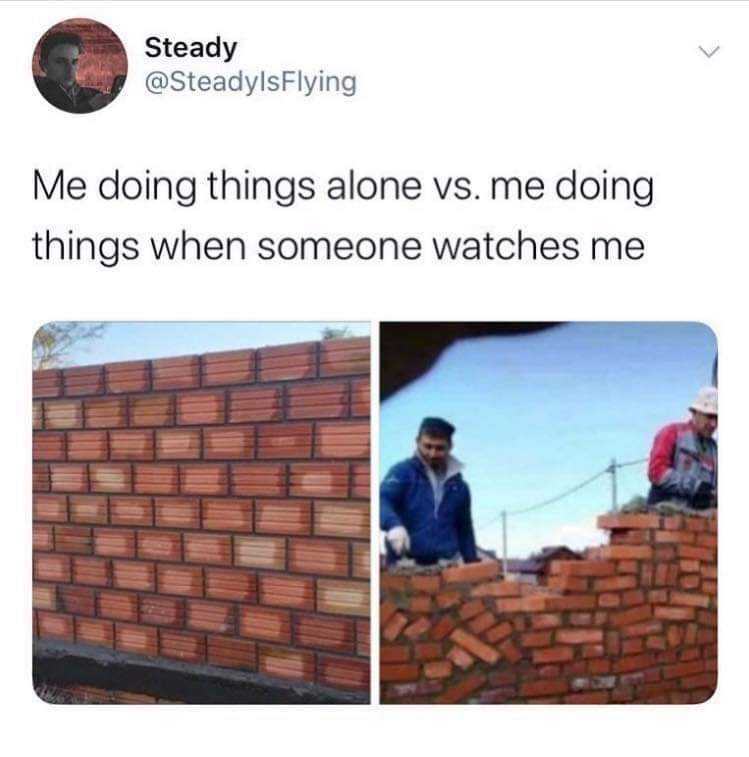 a couple of men standing next to a brick wall with a brick wall