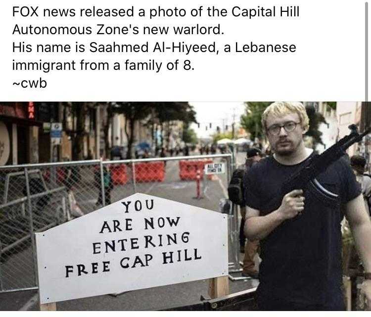 man holding a gun and a sign that reads fox news released a photo of the capital hill