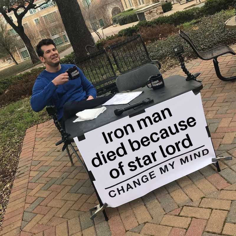 man sitting at a table with a sign that reads iron man died because of star lord change my mind