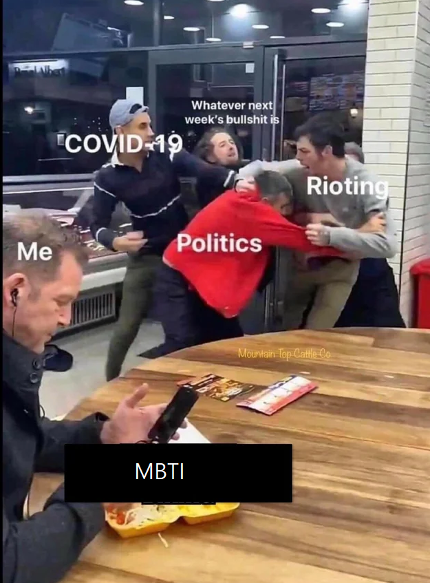 people are sitting at a table with a phone and a man in a red shirt