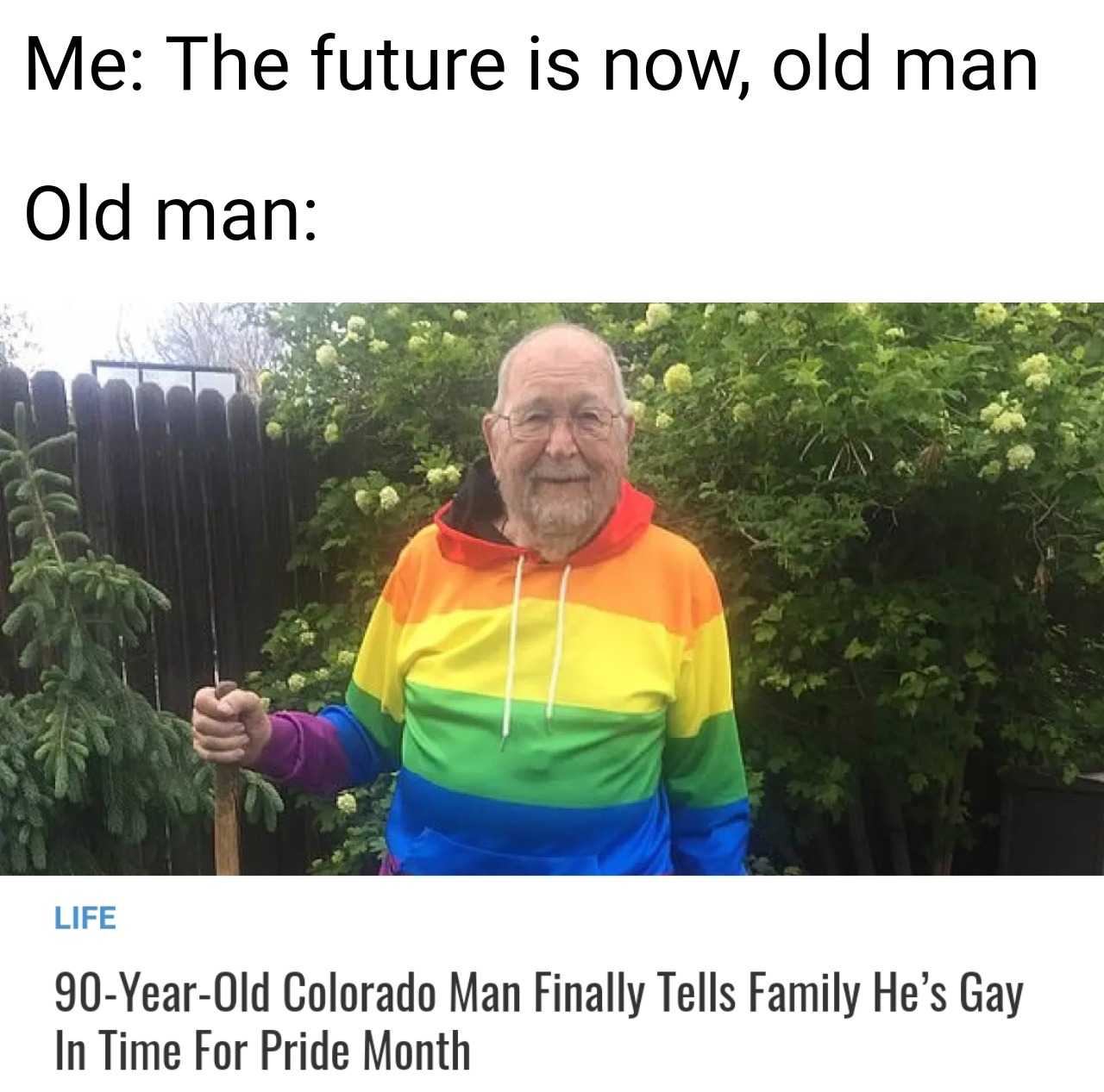 man in a rainbow hoodie holding a stick in his hand