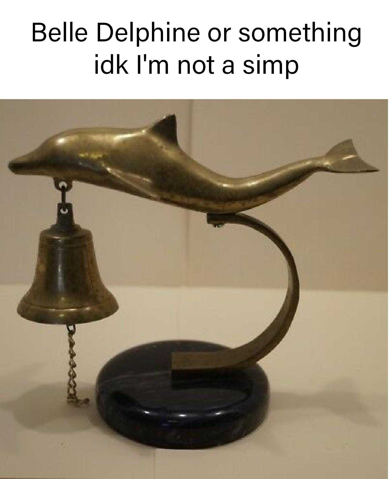 there is a dolphin statue with a bell on it