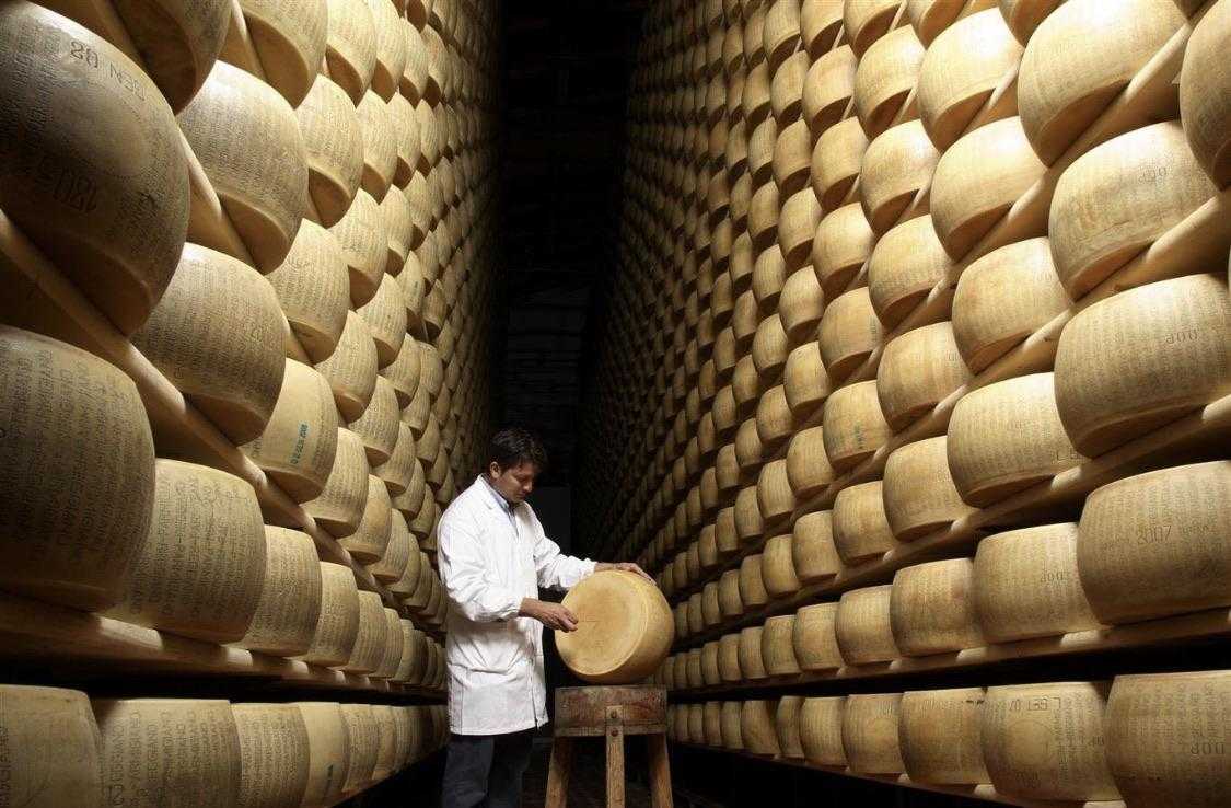 araffe worker in a factory with a large stack of cheese