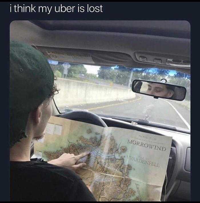 man in a car looking at a map while driving