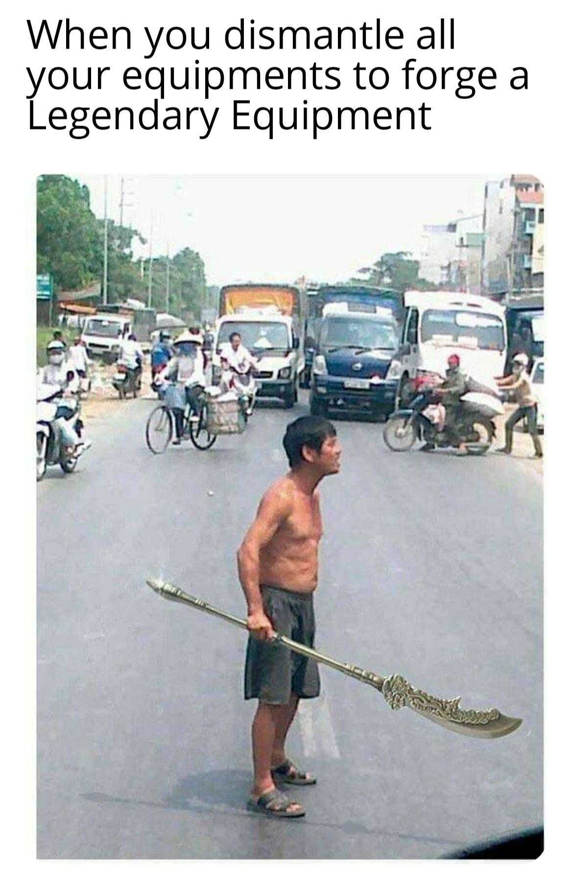 man holding a broom on a street with a lot of traffic