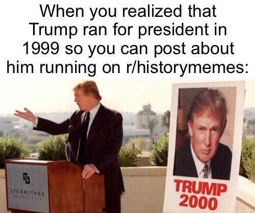 picture of a man standing at a podium with a poster of president trump