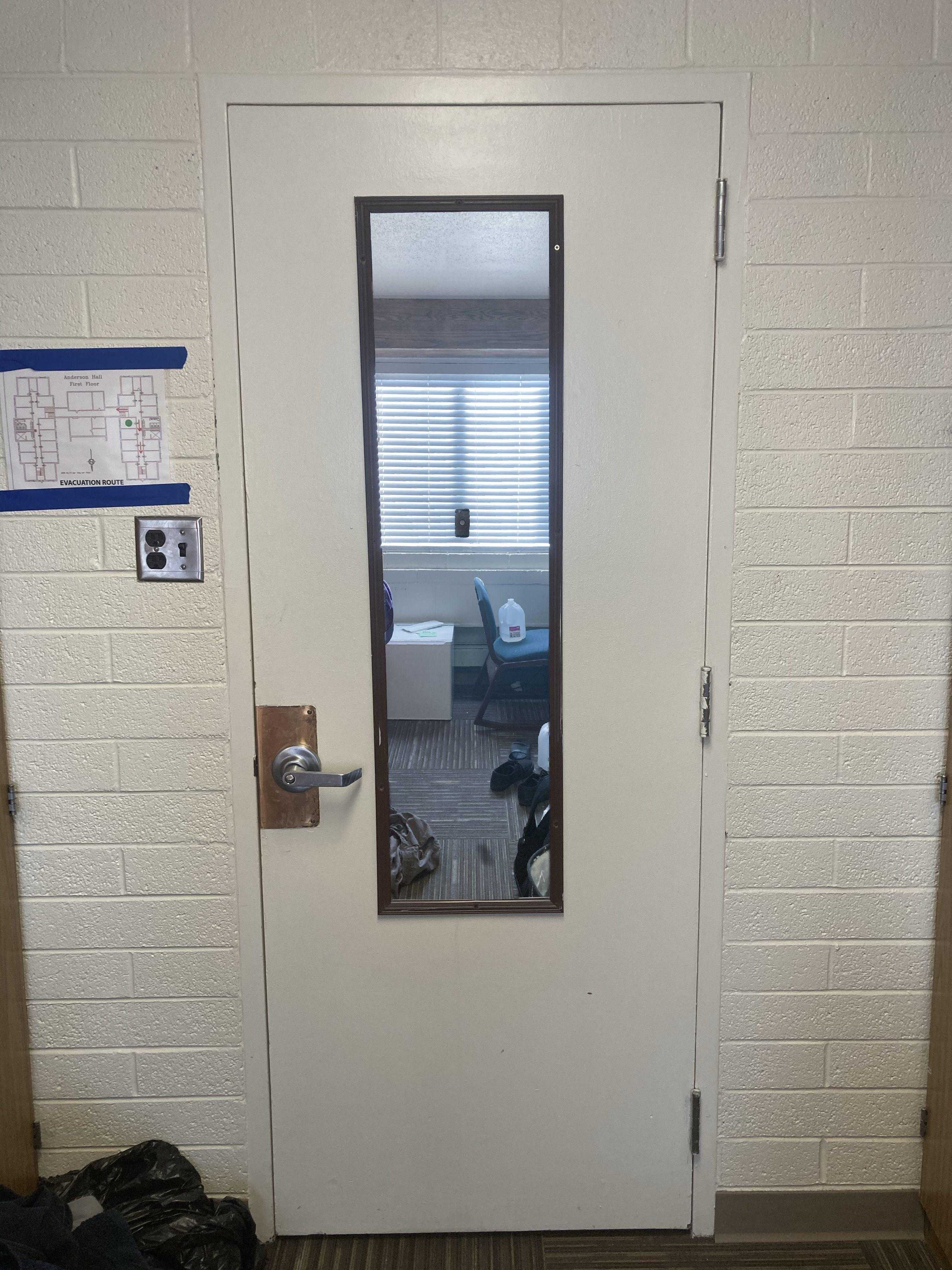 there is a mirror on the door of a room with a chair