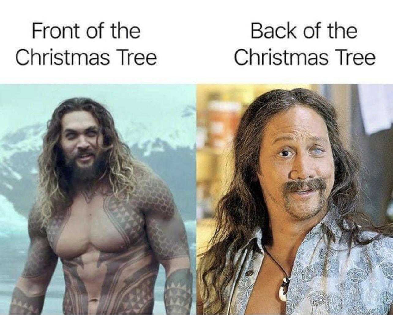 man with long hair and beard standing next to a christmas tree