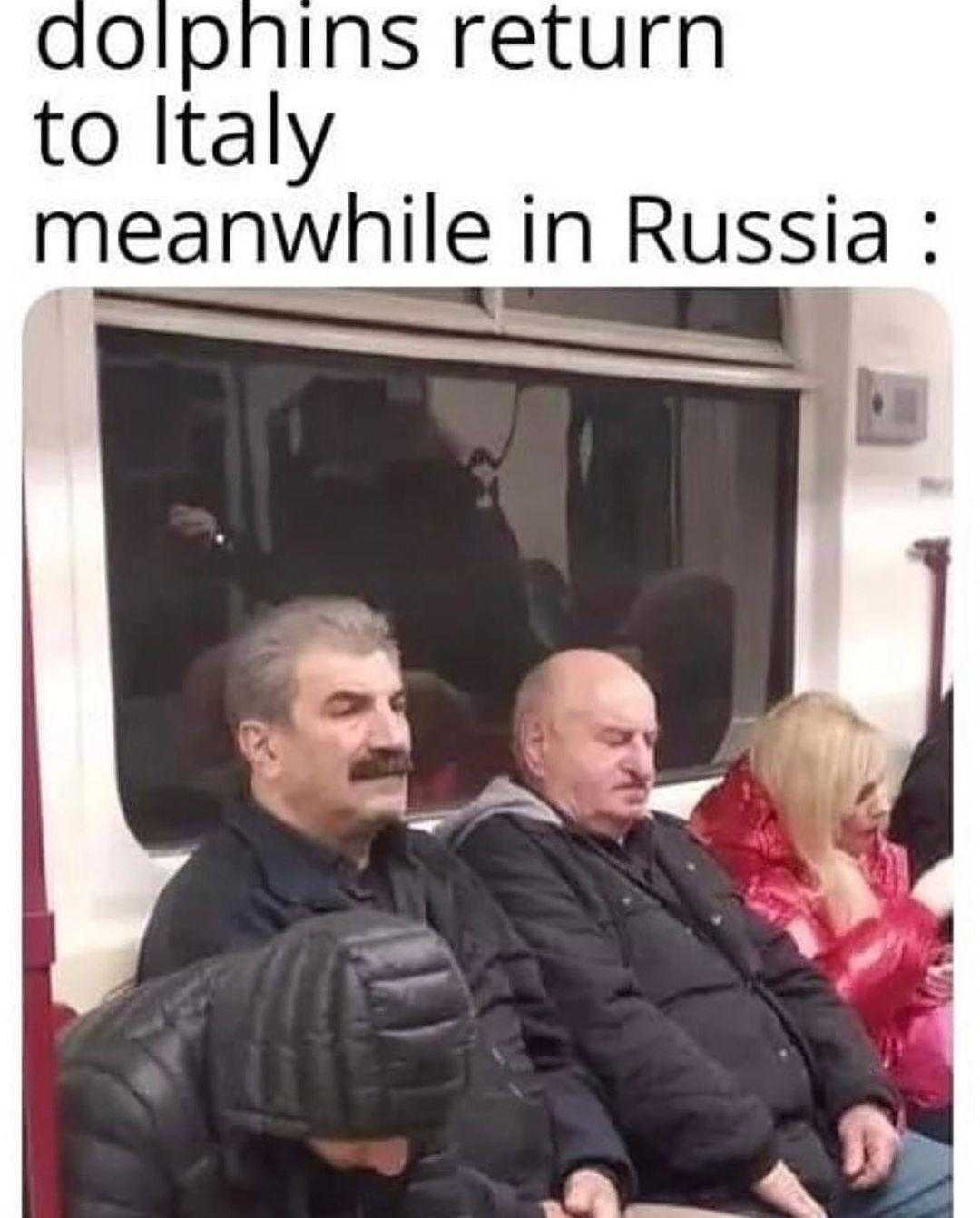 man in a black jacket sitting on a subway train