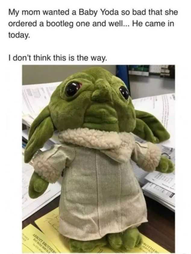 a close up of a stuffed yoda doll on a desk