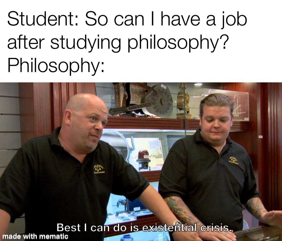 two men in black shirts are sitting at a table with a laptop