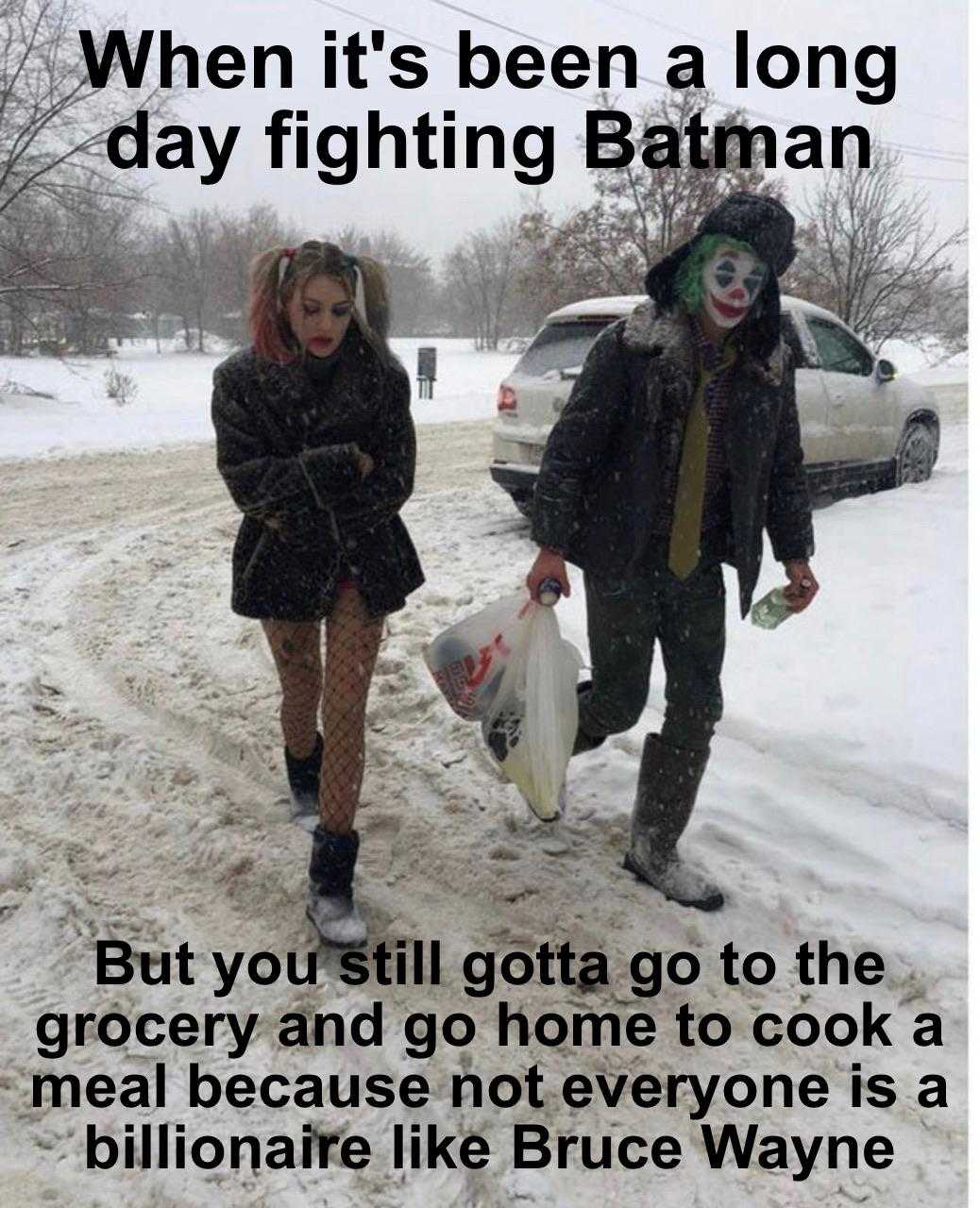 batman and girl walking in the snow with a bag of groceries