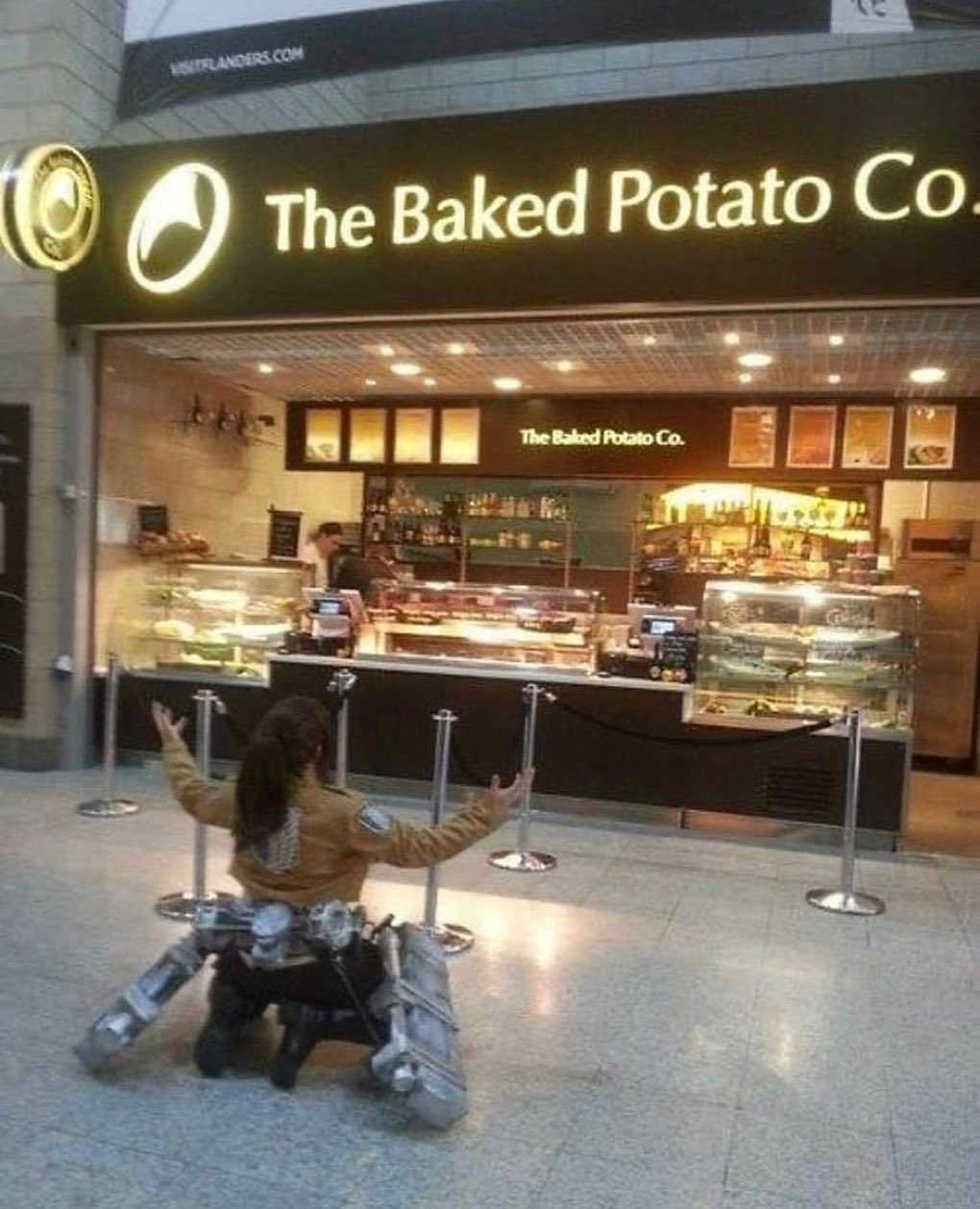 there is a woman sitting on a stool in front of a bakery