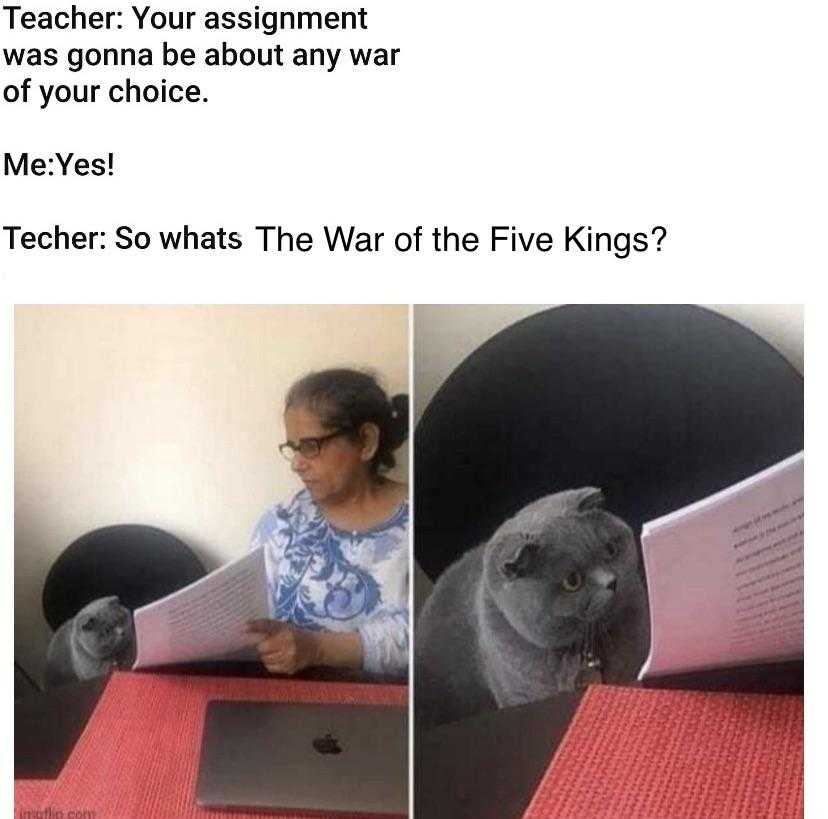 cat sitting on a desk with a piece of paper in front of it