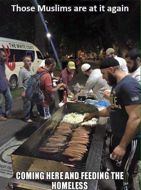 there are many people standing around a grill with food on it