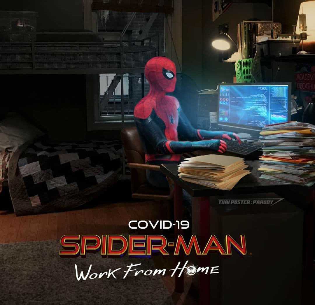 spider - man in a suit sitting at a desk with a laptop