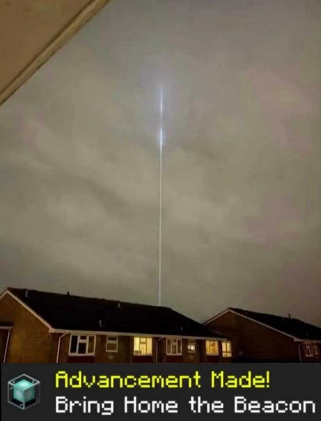 a picture taken from a home shows a long beam of light in the sky