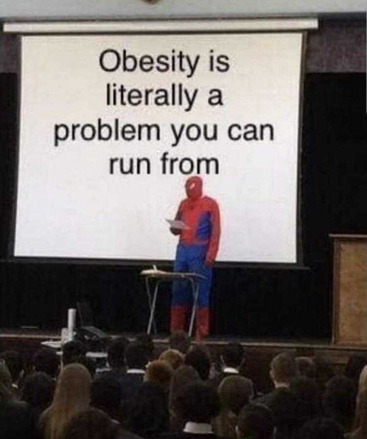 man in a spider suit standing on a stage with a screen behind him