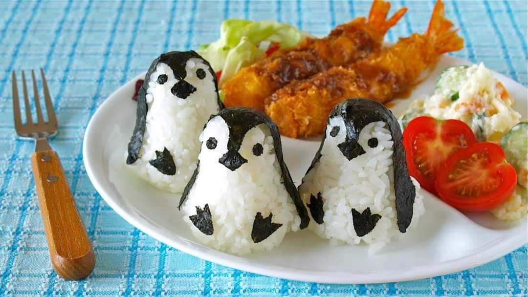 there are three penguins made of rice on a plate with a fork