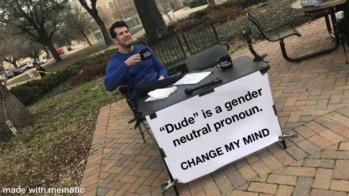 man sitting at a table with a sign that says dude is a gender neutral pro - pornin change my mind