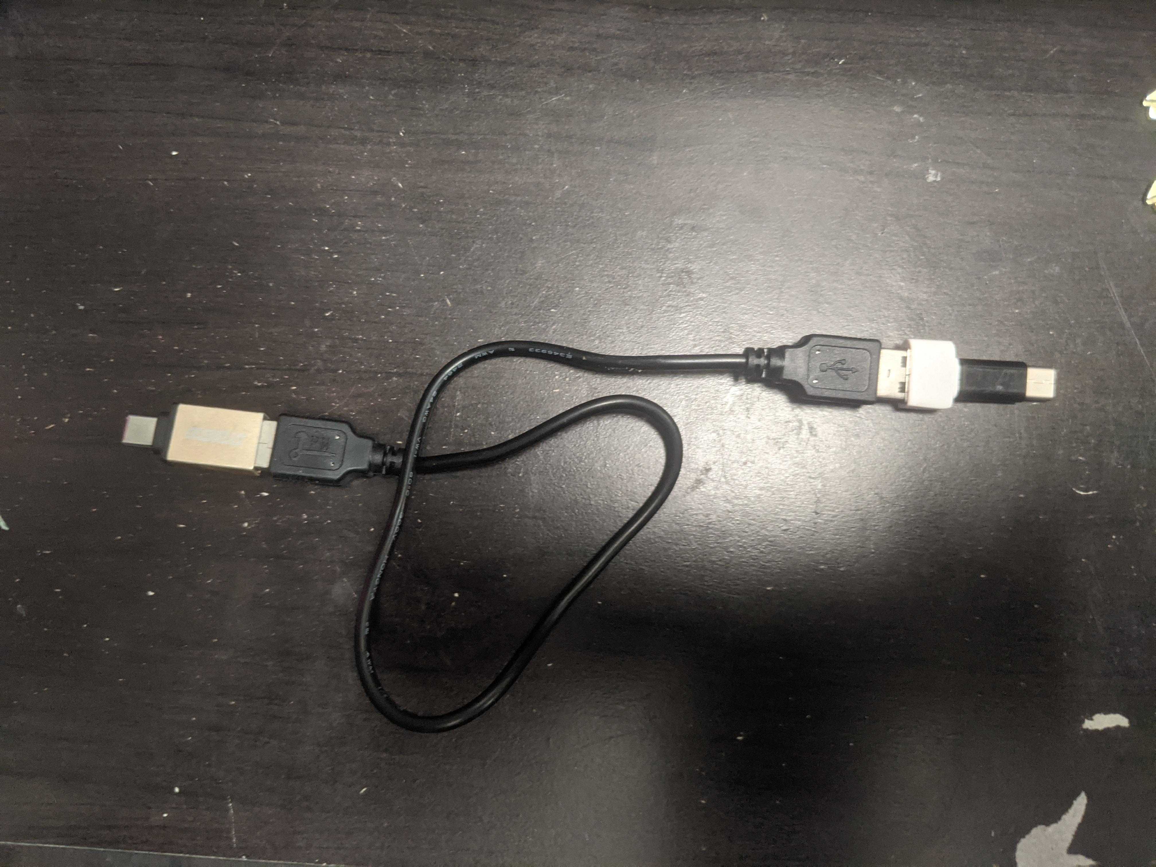 there is a black table with a black and white cable connected to a black and white mouse