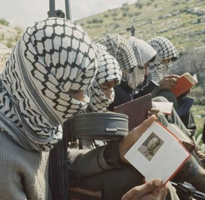 several people in a line with a book and a gun