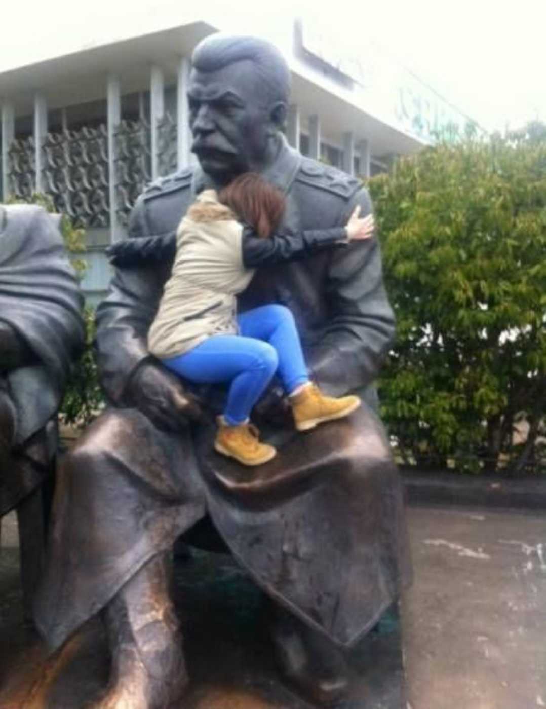 araffe sitting on a statue of a man and a woman