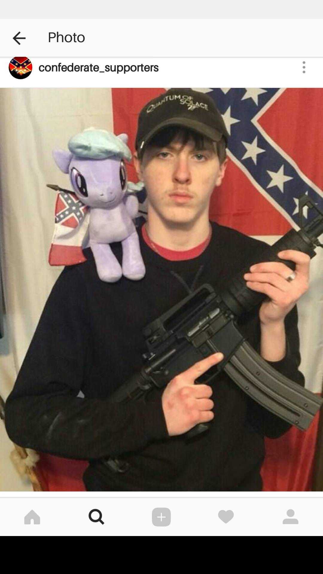 man holding a gun with a stuffed animal on top of it