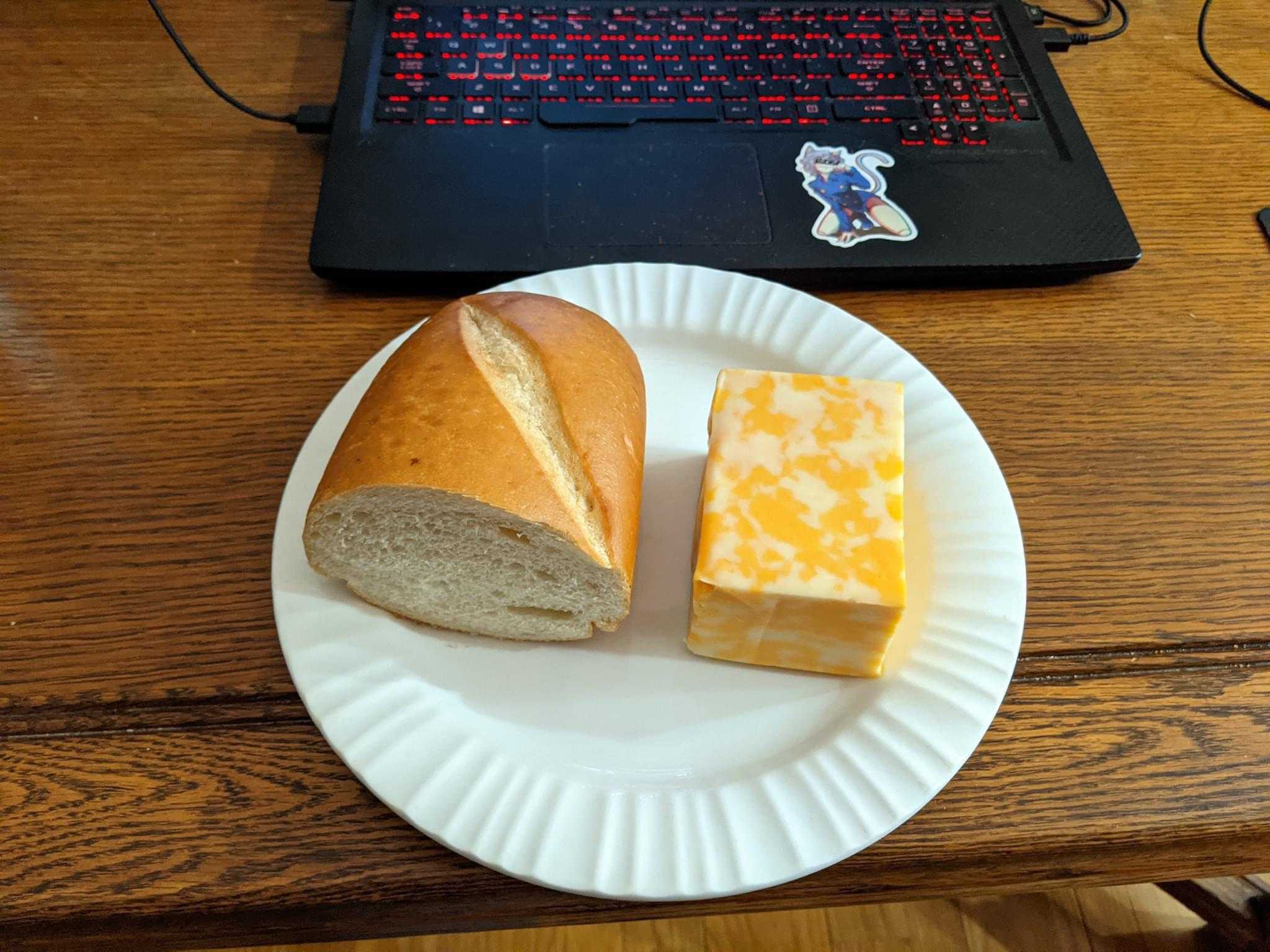 there is a sandwich and cheese on a paper plate on a table