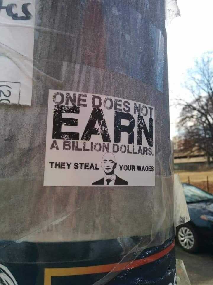 there is a sticker on a pole that says one does not earn a billion dollar