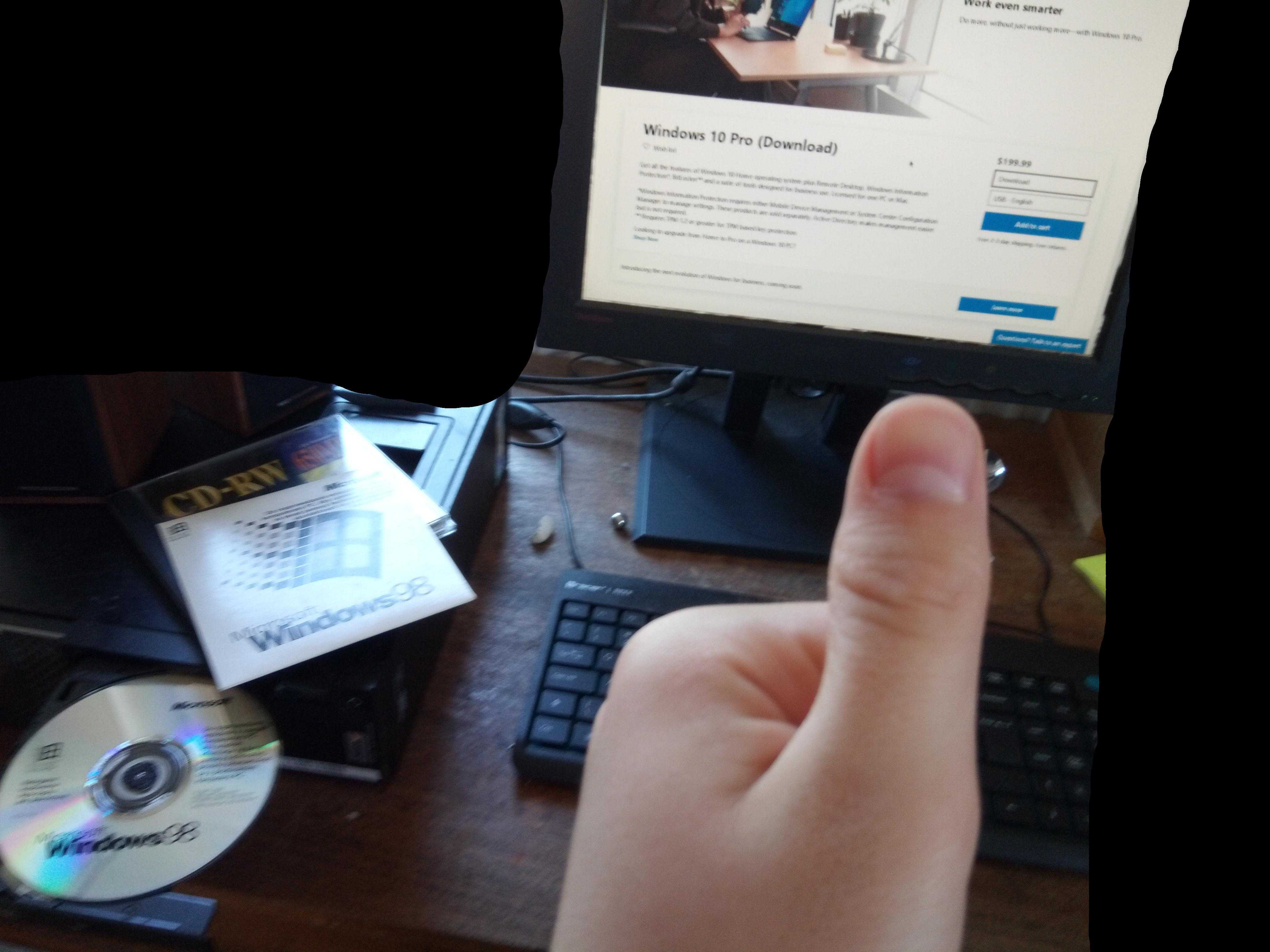 someone is pointing at a computer screen with a cd in front of it