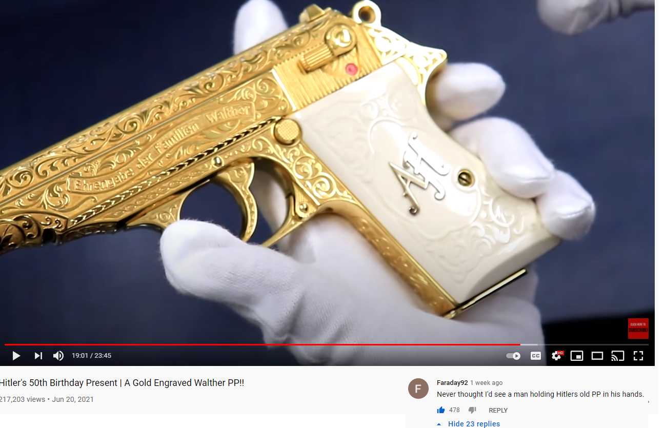 a close up of a person holding a gold gun in their hand