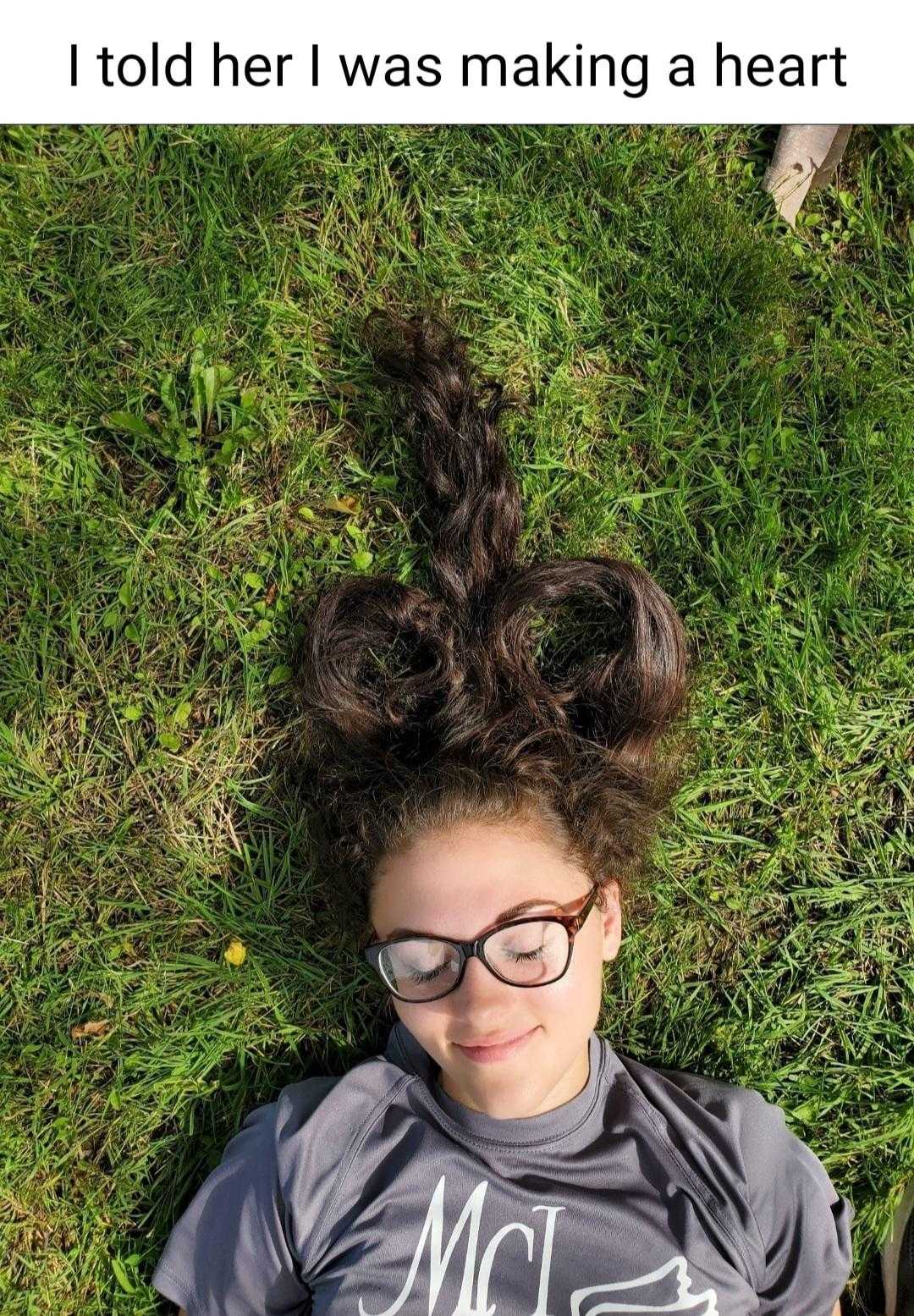 woman laying in the grass with her hair in the air